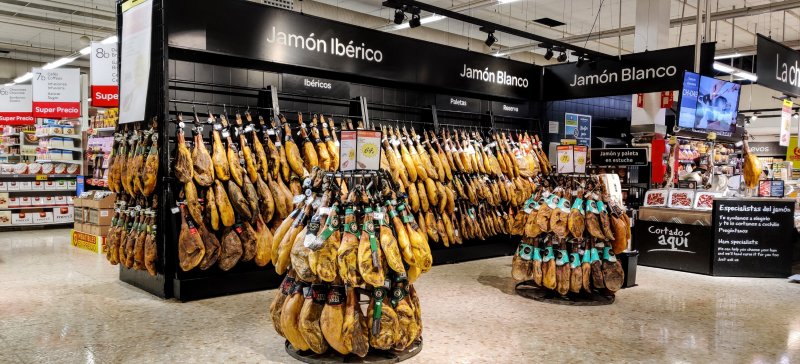 Lots of ham hanging in the grocery store
